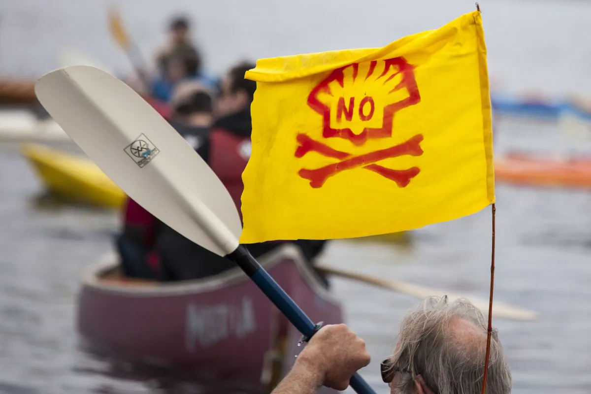 A ShellNo flotilla participant paddles in a kayak with an anti-Shell flag during demonstrations against Royal Dutch Shell on May 16, 2015 in Seattle, Washington. (David Ryder/Getty Images)