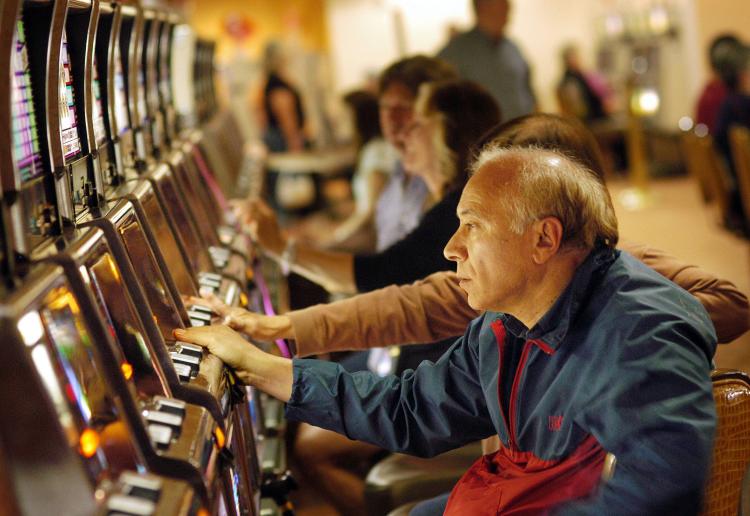 Gamblers play the slots. Michael Lee of Victoria is suing the B.C. Lottery Corporation for refusing to pay his winnings of $42,500 because he had asked to be banned from casinos. (William Thomas Cain/Getty Images)