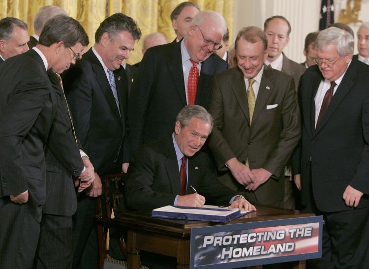 TOUGH ACT TO FOLLOW: Surrounded by members of Congress and Cabinet members, then President George W. Bush signs The USA PATRIOT and Terrorism Prevention Re-authorization Act of 2005. The Act had come under criticism from some in Congress for the potential to infringe of civil liberties but was pushed by the Bush administration as essential for fighting terrorism. (Mark Wilson/Getty Images) TOUGH ACT TO FOLLOW: Surrounded by members of Congress and Cabinet members, then President George W. Bush signs The USA PATRIOT and Terrorism Prevention Re-authorization Act of 2005. The Act had come under criticism from some in Congress for the potential to infringe of civil liberties but was pushed by the Bush administration as essential for fighting terrorism. (Mark Wilson/Getty Images)