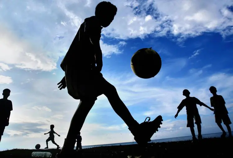 Children playing soccer in a field in a stock photo (Jewl Samad/Getty Images )