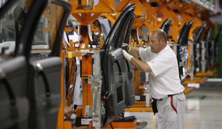 Audi cars sit on the assembly line of ne In this file photo, a plant worker is seen assembling Audi car doors at the company's plant in Brussels, Belgium. Audi is in the process of setting up a production plant in Mexico to meet higher demand. (Benoit Doppagne/AFP/Getty Images)
