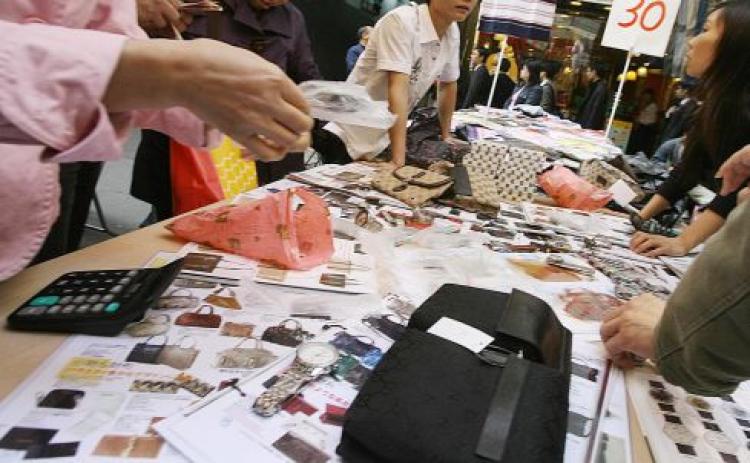 People look at photographs of counterfeit designer bags and watches at a market in the Mong Kok district of Hong Kong 28 November 2007. (Mike Clarke/AFP/Getty Images) People look at photographs of counterfeit designer bags and watches at a market in the Mong Kok district of Hong Kong 28 November 2007. (Mike Clarke/AFP/Getty Images)