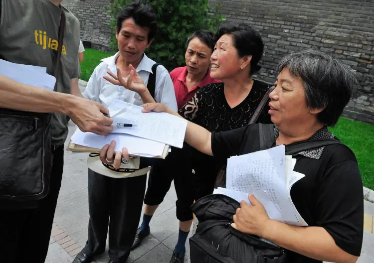 Chinese petitioners show their documents listing their grievances to a reporter near a petition office in Beijing on July 2, 2008. (Teh Eng Koon/AFP/Getty Images)