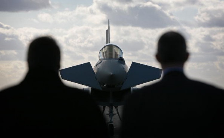 Two men from the ministry of defence watch one of the new Typhoon Tranche type 2 aircraft arrive at RAF Coningsby, on October 21, 2008 in Lincolnshire, England. BAE systems say dropping Typhoon jet orders are partly responsible for the loss of 3,000 jobs. (Christopher Furlong/Getty Images) Two men from the ministry of defence watch one of the new Typhoon Tranche type 2 aircraft arrive at RAF Coningsby, on October 21, 2008 in Lincolnshire, England. BAE systems say dropping Typhoon jet orders are partly responsible for the loss of 3,000 jobs. (Christopher Furlong/Getty Images)