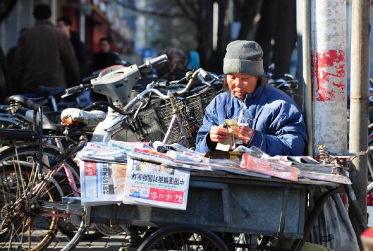 A newspaper vendor counts her one yuan (or RMB) notes in Beijing.  (Frederic J Brown/AFP/Getty Images)
