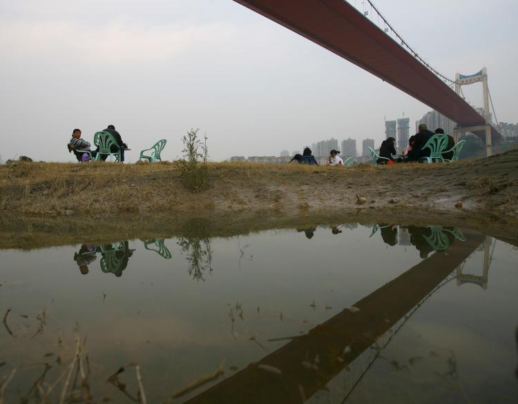 Residents drink tea beneath a bridge across the Yangtze River on November 28, in Chongqing. The Yangtze River has reached its flood peak this week. (China Photos/Getty Images) Residents drink tea beneath a bridge across the Yangtze River on November 28, in Chongqing. The Yangtze River has reached its flood peak this week. (China Photos/Getty Images)
