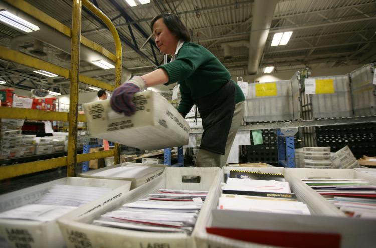 A U.S. Postal worker moves boxes of letters and cards at the U.S. Post Office sort center December 15, 2008 in San Francisco, California. The Postmaster General testified to Congress that USPS might have to cut one day from its delivery schedule, due to r (Justin Sullivan/Getty Images) A U.S. Postal worker moves boxes of letters and cards at the U.S. Post Office sort center December 15, 2008 in San Francisco, California. The Postmaster General testified to Congress that USPS might have to cut one day from its delivery schedule, due to r (Justin Sullivan/Getty Images)