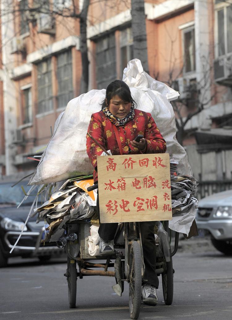 A woman rides a tricyle loaded with recyclable materials in Beijing. (Liu Jin/AFP/Getty Images) A woman rides a tricyle loaded with recyclable materials in Beijing. (Liu Jin/AFP/Getty Images)