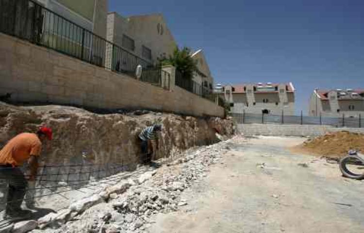 Palestinian workers build new houses at the Israeli West Bank settlement of Adam, north of Jerusalem on June 29, 2009. (Ahmad Gharabli/AFP/Getty Images) Palestinian workers build new houses at the Israeli West Bank settlement of Adam, north of Jerusalem on June 29, 2009. (Ahmad Gharabli/AFP/Getty Images)