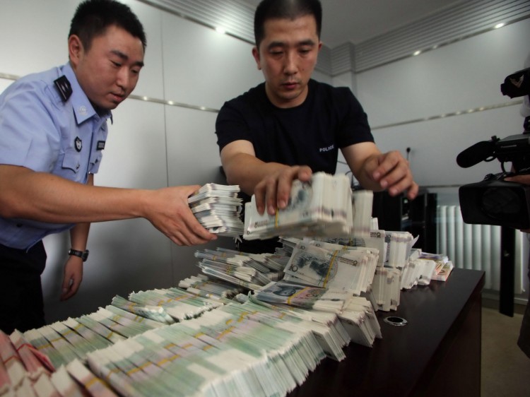 88987960 Chinese police officers present counterfeit yuan notes