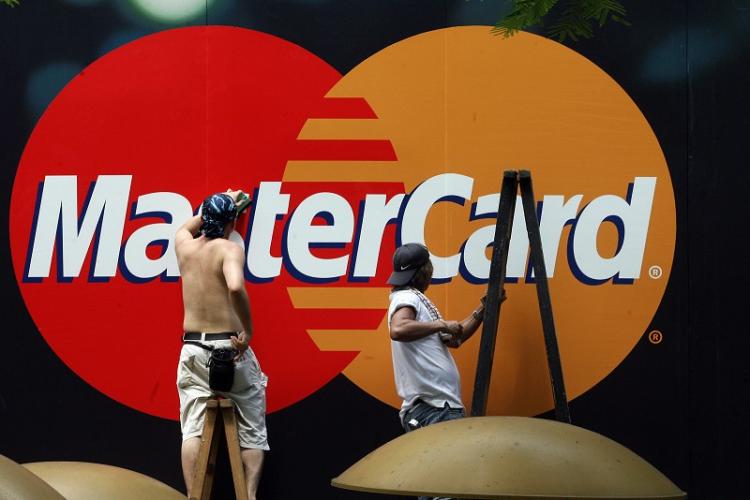 Workers clean a Mastercard advertisement in China. Credit card debt overdue by six month or more has risen sharply since last year. (Mike Clarke/AFP/Getty Images) Workers clean a Mastercard advertisement in China. Credit card debt overdue by six month or more has risen sharply since last year. (Mike Clarke/AFP/Getty Images)
