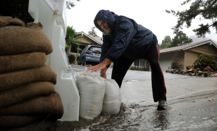 TROUBLE: Dan McLathan places sandbags outside his house, as heavy rain raises the possibility of flooding and landslides in Los Angeles on Dec. 7. Los Angeles police were to go door-to-door notifying the affected residents.  (Mark Ralston/AFP/Getty Images)