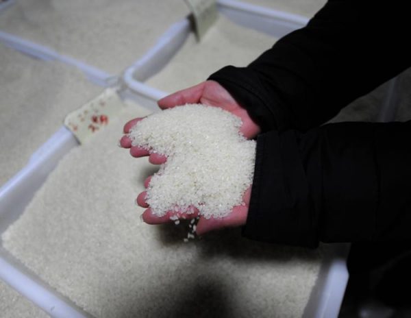 A vendor picks up rice at her stall in a market in Beijing. For decades, high levels of cadmium and other toxic heavy metals have polluted China's waterways and through irrigation they have ended up in village rice paddies. (Peter Parks/Getty Images)