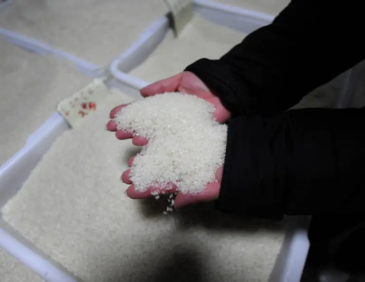 A vendor picks up rice at her stall in a market in Beijing. For decades, high levels of cadmium and other toxic heavy metals have polluted China's waterways and through irrigation they have ended up in village rice paddies. (Peter Parks/Getty Images)