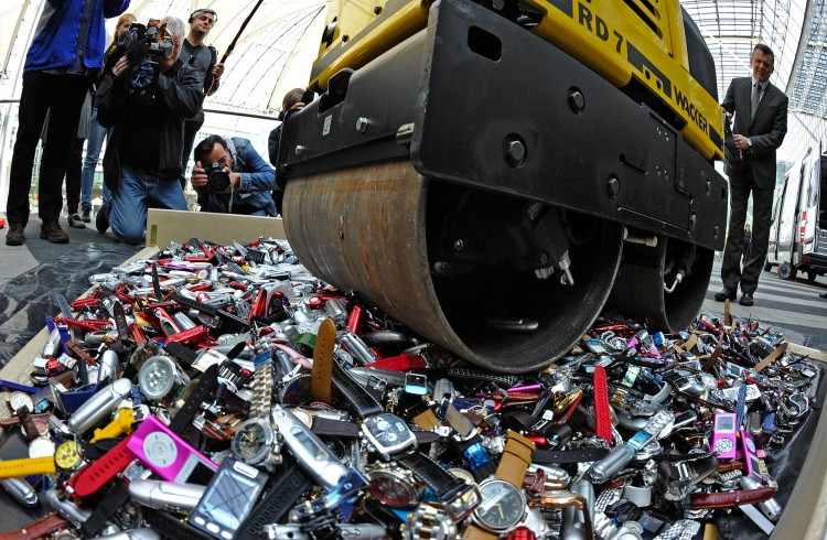 Customs officers use a roller to destroy Epoch Times Photo