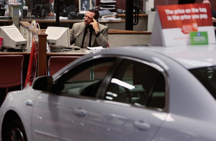 DEALER WOES: A car salesman works at his desk in a car showroom in New York City. U.S. automakers announced the closure of 988 dealerships in 2008. (Chris Hondros/Getty Images)
