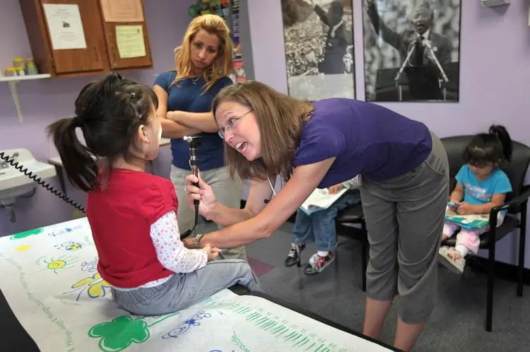 A physician's assistant checks the throat of a sick child in this file photo. (John Moore/Getty Images)