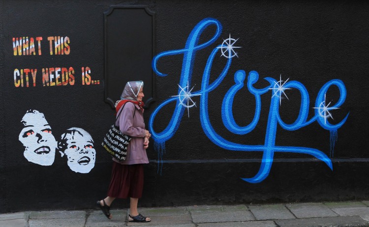 HOPE: In a file picture taken on November 25th, 2011, a woman walks past a wall covered in graffiti, which reads 'What This City Needs Is Hope' on a building in Dublin, Ireland. HOPE: In a file picture taken on November 25th, 2011, a woman walks past a wall covered in graffiti, which reads 'What This City Needs Is Hope' on a building in Dublin, Ireland.