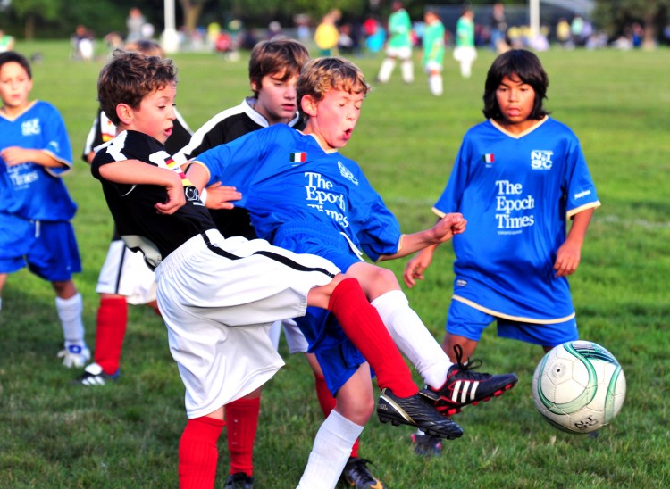 Epoch Times-Team Italy's and Davenport Kitchens-Team Germany's 11-year-old teammates work hard for the ball. (Gordon Yu/The Epoch Times) Epoch Times-Team Italy's and Davenport Kitchens-Team Germany's 11-year-old teammates work hard for the ball. (Gordon Yu/The Epoch Times)
