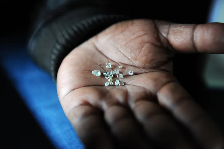 A miner displays diamonds dug out of a disused mine in Komaggas, South Africa, in June 2012. (Alexander Joe/AFP/Getty Images) 