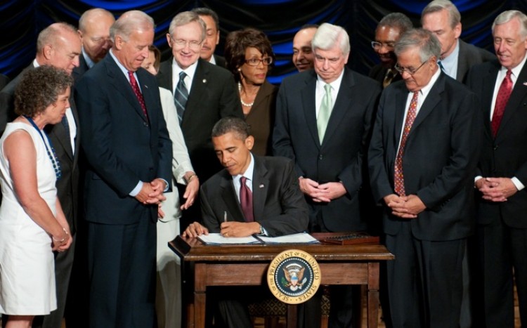 President Barack Obama signs the Dodd-Frank Wall Street Reform and Consumer Protection Act alongside members of Congress, the administration and U.S. Vice President Joe Biden at the Ronald Reagan Building in Washington, D.C., July 21, 2010. (Photo ROD LAMKEY JR/AFP/Getty Images)