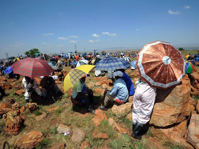 Striking miners protest on the hill at the AngloGold Ashanti mine in Carletonville, 52 miles (84km) northwest of Johannesburg, on Oct. 22. AngloGold Ashanti, the world's third-largest gold producer, on Tuesday issued an ultimatum to striking workers in South Africa that they must return to the mines Wednesday or be dismissed. (Alexander Joe/AFP/Getty Images)