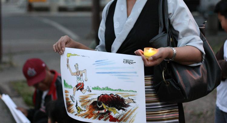 RIGHTS TRAMPLED: Tibet supporter holds a commentary cartoon on the Beijing Olympics during a candlelight vigil at the Chinese Consulate in Calgary on August 7. (Neil Campbell/The Epoch Times) RIGHTS TRAMPLED: Tibet supporter holds a commentary cartoon on the Beijing Olympics during a candlelight vigil at the Chinese Consulate in Calgary on August 7. (Neil Campbell/The Epoch Times)