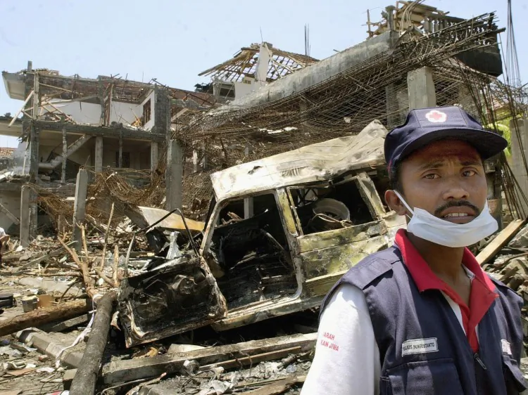An Indonesian Red Cross volunteer stands at the site of the car bombing in Kuta, Bali, Oct. 14, 2002. The Bali bombing was devastating, killing 200 people but has resulted in stronger ties between Australia and Indonesia. (Oka Budhi/Getty Images)