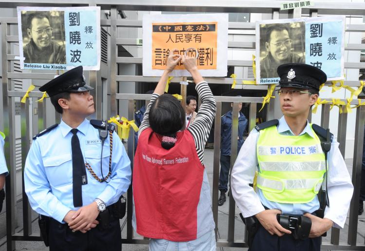 A woman puts a sign on the gate outside the China liaison office in Hong Kong to protest the Chinese regime's jailing of dissident Lui Xiaobo on Dec. 25, 2009, after a Beijing court sentenced the prominent writer and pro-democracy activist to 11 years in prison despite international calls for his release. (MIKE CLARKE/AFP/Getty Images) A woman puts a sign on the gate outside the China liaison office in Hong Kong to protest the Chinese regime's jailing of dissident Lui Xiaobo on Dec. 25, 2009, after a Beijing court sentenced the prominent writer and pro-democracy activist to 11 years in prison despite international calls for his release. (MIKE CLARKE/AFP/Getty Images)