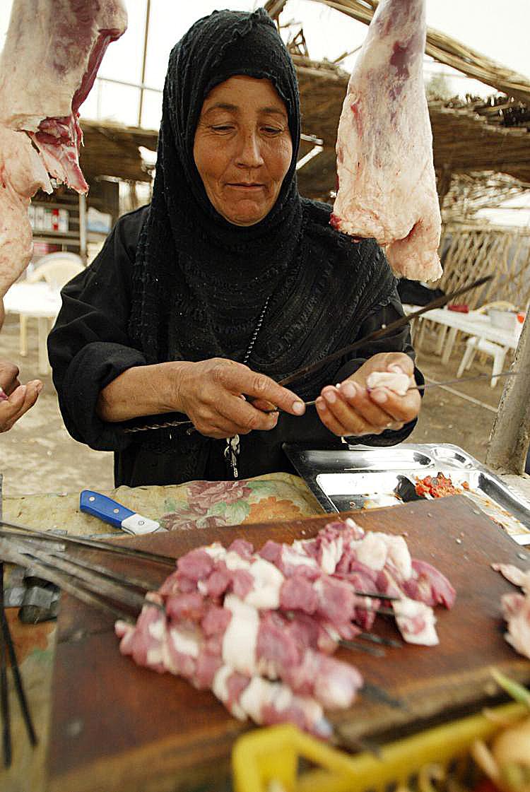 An Iraqi woman sells meat at her street stall in Baghdad. Micro lending attempts to help small entrepreneurs in developing countries establish a foothold and rise above poverty. (Ali Yussef/AFP/Getty Images ) An Iraqi woman sells meat at her street stall in Baghdad. Micro lending attempts to help small entrepreneurs in developing countries establish a foothold and rise above poverty. (Ali Yussef/AFP/Getty Images )