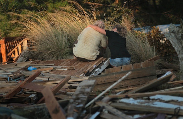 A man is comforted by a friend while he sits next to a pile of debris that was once his cottage, Aug. 28 in Nags Head, N.C. The cottage, built in 1903, was destroyed by Hurricane Irene. (Scott Olson/Getty Images) A man is comforted by a friend while he sits next to a pile of debris that was once his cottage, Aug. 28 in Nags Head, N.C. The cottage, built in 1903, was destroyed by Hurricane Irene. (Scott Olson/Getty Images)