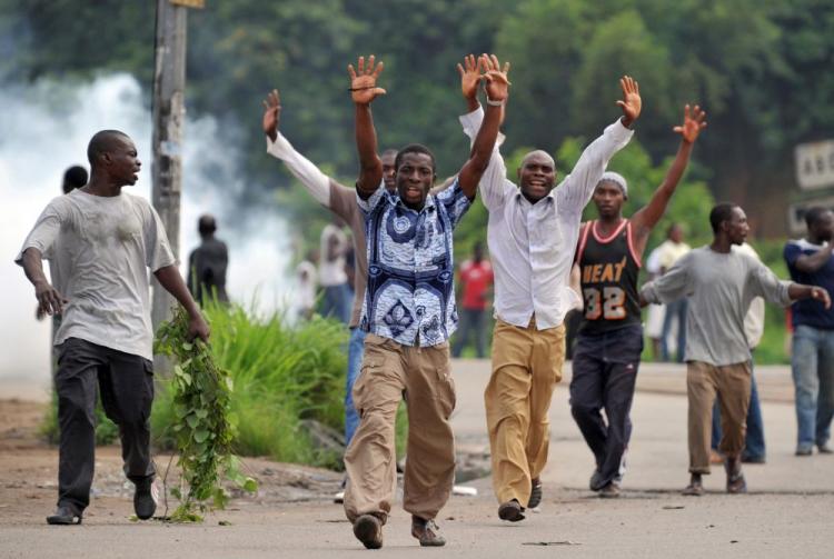 Supporters of Alassane Ouattara, who has been internationally recognized as the winner of last month's presidential election, raise their arms during a protest in Abidjan on Dec. 16. The incumbent president, Laurent Gbagbo, has refused to step down from power. (Issouf Sanogo/AFP/Getty Images)