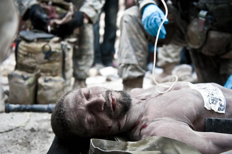 US paratroopers from the 82nd airborne surround a man who was rescued from under the rubble in Port-au-Prince on Jan. 26.  (FRED DUFOUR/AFP/Getty Images)