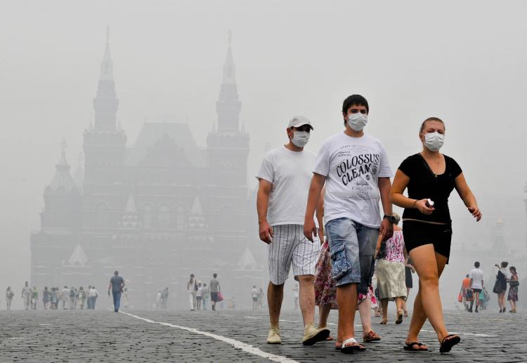 TOXIC SMOG: Russians wear face masks to protect themselves from forest fire smog while walking on Red Square in Moscow on Aug. 6. Smog from wildfires in the countryside cloaked Moscow, with levels of toxic particles, raising alarm over public health and numerous commuters wearing anti-pollution masks.(Natalia Kolenisova/Getty Images)