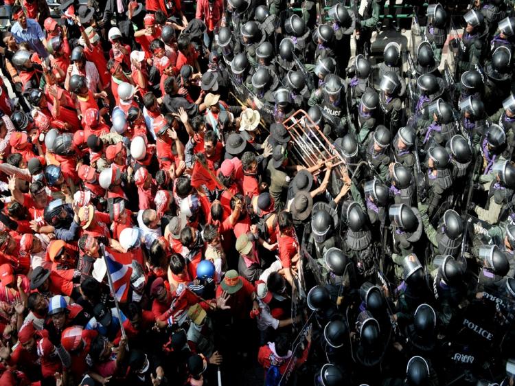 Red-shirted supporters (L) of fugitive former Thai premier Thaksin Shinawatra clash with Thai riot police officers during continued anti-government protests in central Bangkok on April 10. (NICOLAS ASFOURI/AFP/Getty Images)