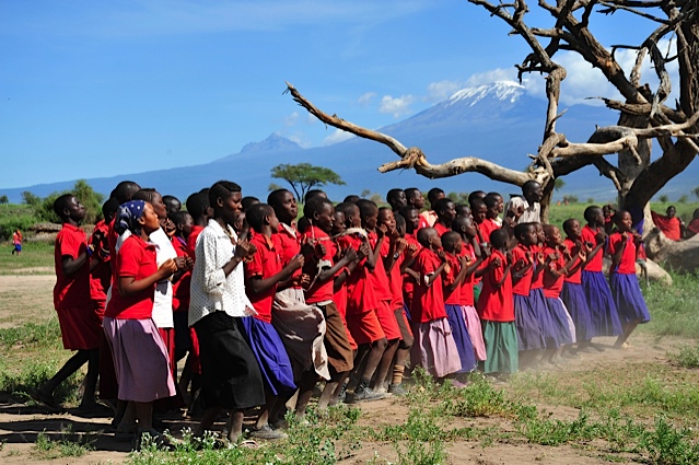 Students from Esiteti Primary School sing with Mount Kilimanjaro in the background. (Courtesy of ASK) Students from Esiteti Primary School sing with Mount Kilimanjaro in the background. (Courtesy of ASK)