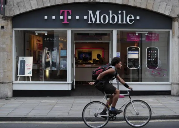 A man cycles past a T-Mobile shop in Fleet Street, London, England. (Carl Court/AFP/Getty Images)