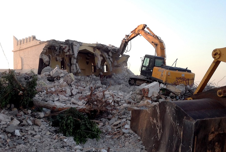 Libyan Islamist hardliners use a bulldozer to raze the mausoleum of Al-Shaab Al-Dahman near the centre of Tripoli on Aug 25. Islamist hardliners bulldozed part of the revered mausoleum in Tripoli in the second such attack in Libya in two day. (Mahmud Turkia/AFP/GettyImages) Epoch Times Photo