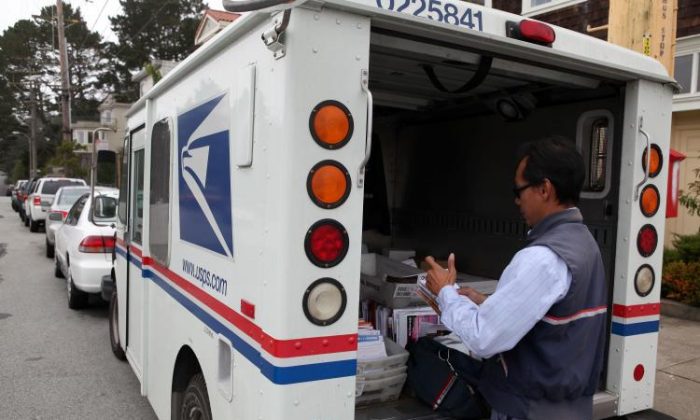 U.S. Postal Service letter carrier Anthony Ow sorts through mail in the back of his delivery truck in San Francisco on July 30, 2009. (Justin Sullivan/Getty Images)
