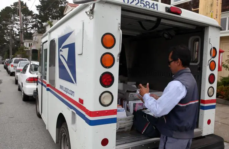 U.S. Postal Service letter carrier Anthony Ow sorts through mail in the back of his delivery truck in San Francisco on July 30, 2009. (Justin Sullivan/Getty Images)