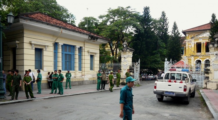 Policemen and security staff stand outside the main entrance gate of Ho Chi Minh City's People's Court where three bloggers were tried for 'anti-state propaganda' on Sept. 24. (STR/AFP/GettyImages)