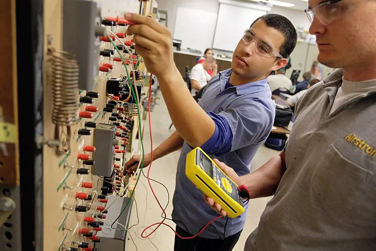 Bryant Batres (L) and Adam Friday (R) continue learning how to service air conditioners at the Air Conditioning, Refrigeration and Pipefitting Education Center in Opa Locka, Fla., on Jan. 5. (Joe Raedle/Getty Images)