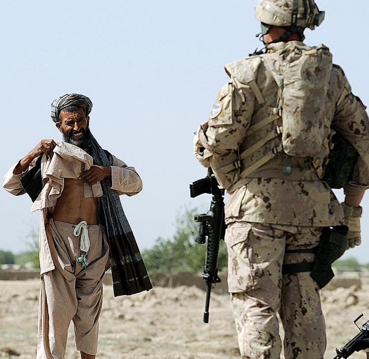 A Canadian soldier with the NATO-led International Security Assistance Force (ISAF) stops an Afghan passer-by during a patrol in Panjwayi district, some 30 kms west of Kandahar province earlier this year. The deaths of two children have brought Canadian s (Shah Marai/AFP/Getty Images) A Canadian soldier with the NATO-led International Security Assistance Force (ISAF) stops an Afghan passer-by during a patrol in Panjwayi district, some 30 kms west of Kandahar province earlier this year. The deaths of two children have brought Canadian s (Shah Marai/AFP/Getty Images)