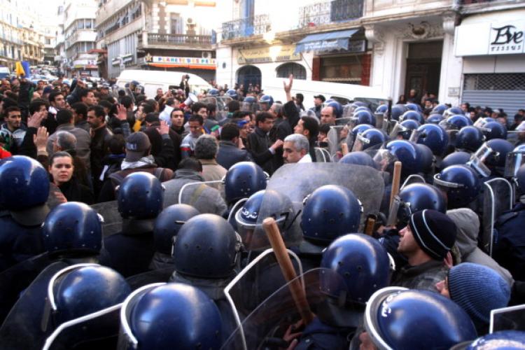 Demonstrators face riot police outside the opposition Rally for Culture and Democracy (RCD) party's headquarters in Algiers on Jan. 22. (STR/AFP/Getty Images) Demonstrators face riot police outside the opposition Rally for Culture and Democracy (RCD) party's headquarters in Algiers on Jan. 22. (STR/AFP/Getty Images)