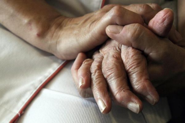 Nurse holds hand of patient