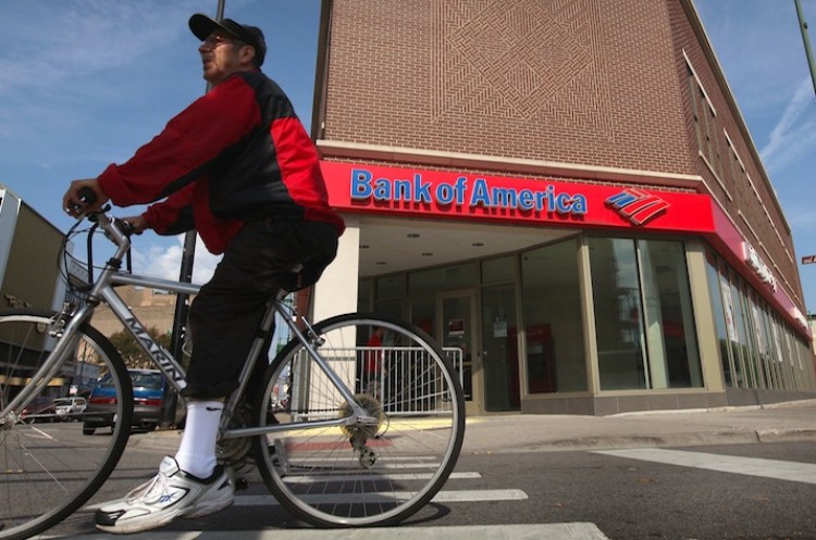 A cyclist rides past a Bank of America branch on Sept. 12 in Chicago. Bank of America was recently downgraded by Moody's Investors Service and faces numerous legal troubles.  (Scott Olson/Getty Images)