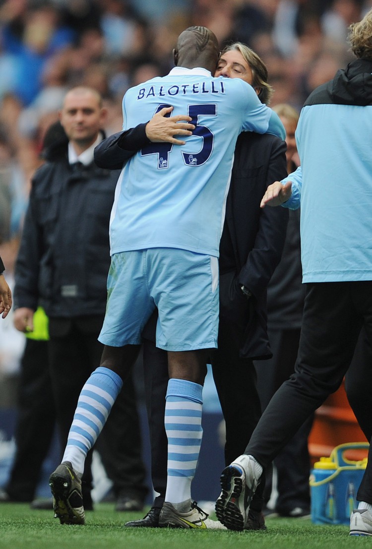 Manchester City striker Mario Balotelli hugs manager Roberto Mancini after scoring the winning goal against Everton on Saturday. (Michael Regan/Getty Images) Manchester City striker Mario Balotelli hugs manager Roberto Mancini after scoring the winning goal against Everton on Saturday. (Michael Regan/Getty Images)