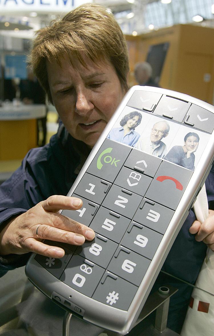 A woman inspects the mockup of a mobile phone with oversized Braille-marked keys. (Nigel Treblin/AFP/Getty Images)
