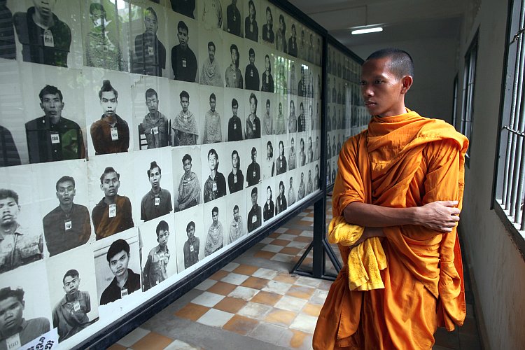 Cambodian monk looks at photos of victims of the Khmer Rouge regim