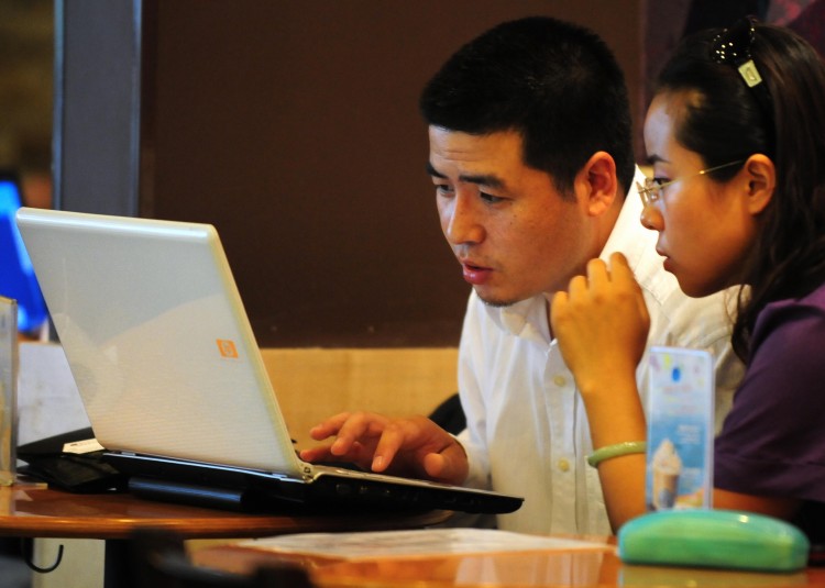 Chinese netizens use a laptop computer at a wireless cafe in Beijing in 2009. China's largest microblog Sina Weibo plans to implement more stringent Internet controls to stamp out 'rumors.' (Frederic J. Brown/AFP/Getty Images)